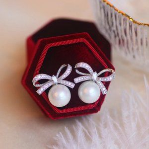 Simulated stud pearl earrings with cubic zirconia bows. Holiday collection.